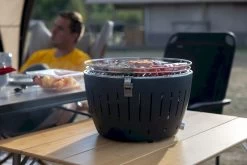 LotusGrill XL Hybrid Houtskoolbarbecue - Rood 22 LotusGrill XL Hybrid Houtskoolbarbecue - Rood -Speciaalzaak Voor Kampeerartikelen lotusgrill in gebruik met toppy shirtje 2