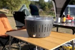 LotusGrill XL Hybrid Houtskoolbarbecue - Rood 21 LotusGrill XL Hybrid Houtskoolbarbecue - Rood -Speciaalzaak Voor Kampeerartikelen lotusgrill in zon op tafel 3